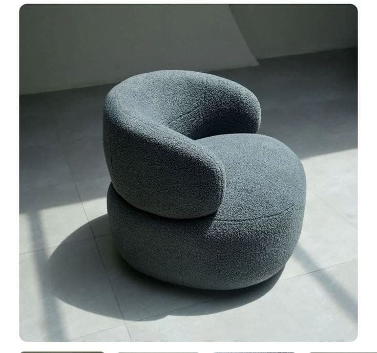 Grey bouclé barrel armchair in studio light